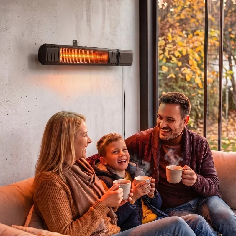 Familie mit Tassen auf dem Sofa, an der Wand darüber der schwarze Heizstrahler im Herbstlicht