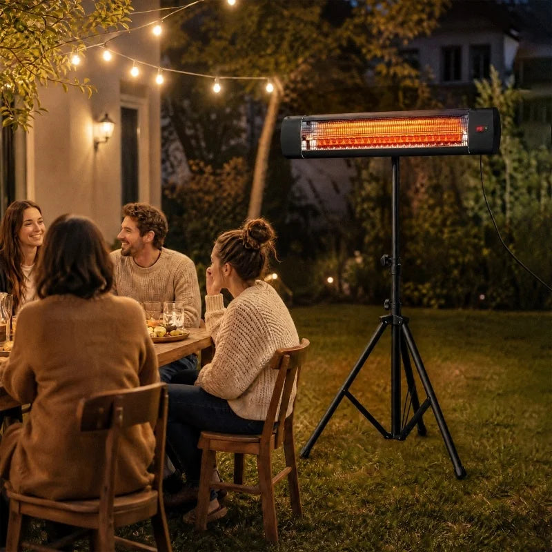 Gruppe am Gartentisch unter Lichterketten, rechts der Heizstrahler auf Dreibeinstativ im Rasen