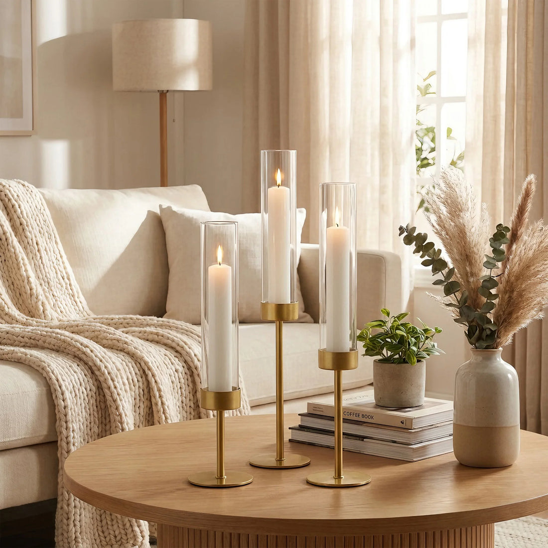 Kerzenständer in Gold auf rundem Couchtisch vor hellem Sofa im Wohnzimmer