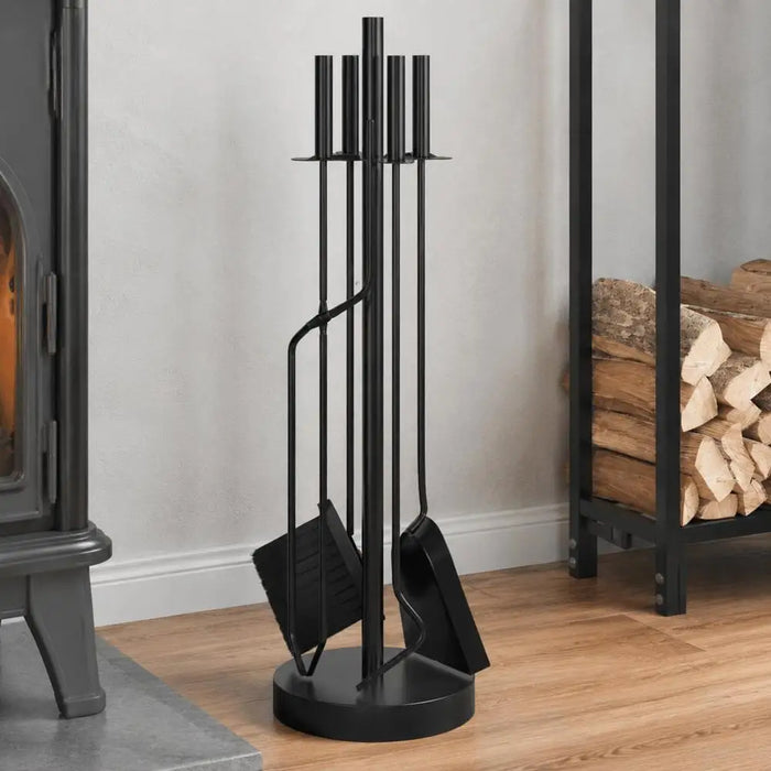 Kaminbesteck-Set aus schwarzem Stahl auf Rundsockel neben einem Kaminofen und einem Holzregal