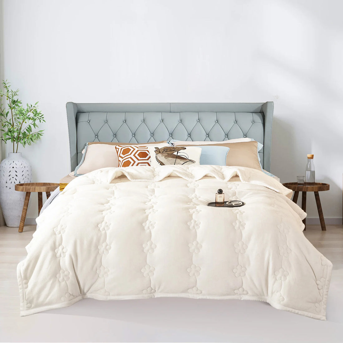Dicke Kuscheldecke in hellem Creme-Beige auf einem Doppelbett mit grauem Polsterkopfteil