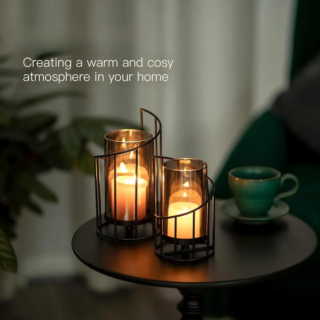 Windlicht-Set mit Rauchglas auf dunklem Beistelltisch neben einer Teetasse