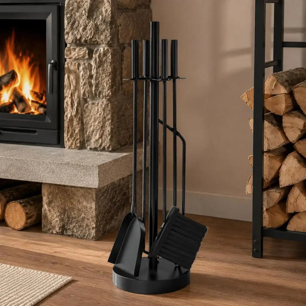 Fünfteiliges Kaminbesteck mit Schaufel und Besen vor einem Kaminofen mit brennendem Feuer