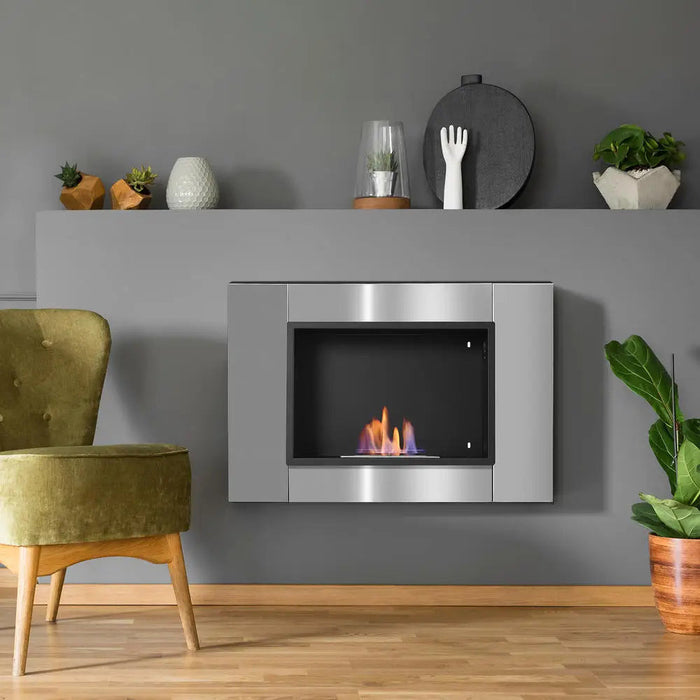 Bioethanol-Kamin aus Edelstahl an grauer Wand unter Wandregal, daneben grüner Sessel
