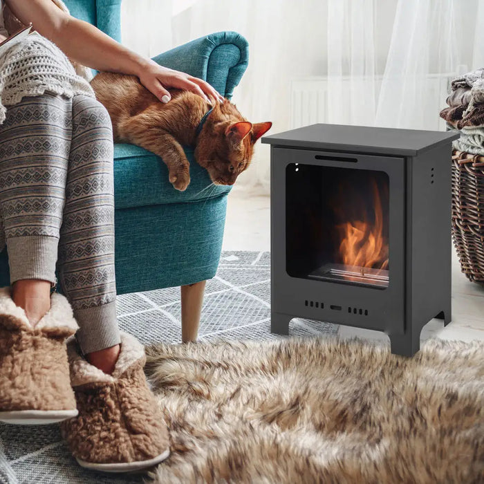 Bioethanol-Kamin im Neo-Retro-Stil auf Fellteppich neben türkisem Sessel, auf der Armlehne eine Katze